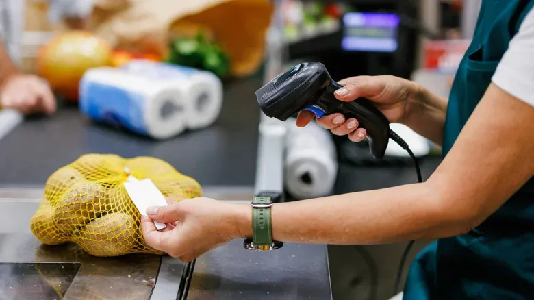 Касиерка сканира баркода на продукт на касата